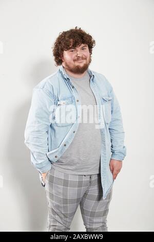 Ritratto giovane sorridente in camicia denim e pantaloni in plaid Foto Stock