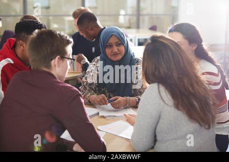 Studenti universitari che parlano e studiano in classe Foto Stock