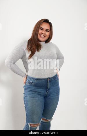 Ritratto giovane donna sicura in maglione e jeans Foto Stock