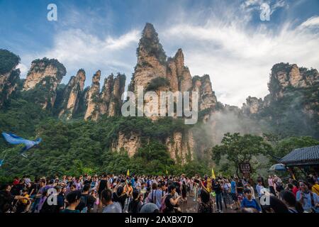 Zhangjiajie, Cina - Agosto 2019 : folle di turisti Enormi sulla piazza in fondo al Bailong ascensore con I Soldati Che Raccolgono picchi behin Foto Stock