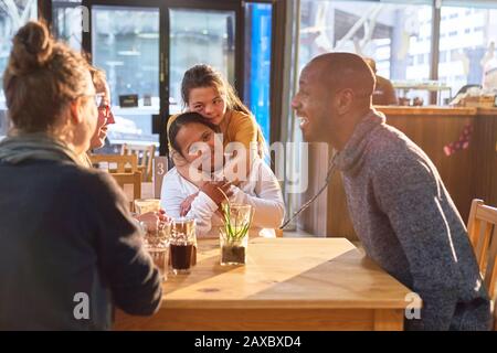 Affettuose giovani donne con sindrome Di Down in caffè con gli amici Foto Stock