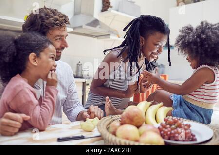 Giovane famiglia che mangia frutta a tavola Foto Stock