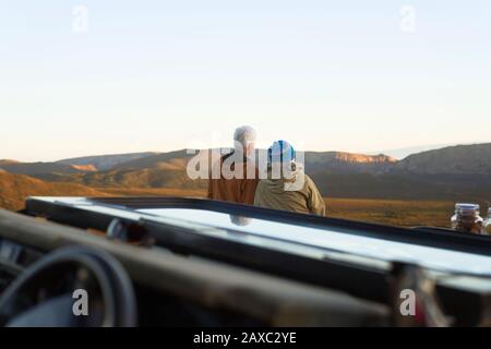 Coppia senior in safari guardando la vista panoramica del paesaggio Foto Stock