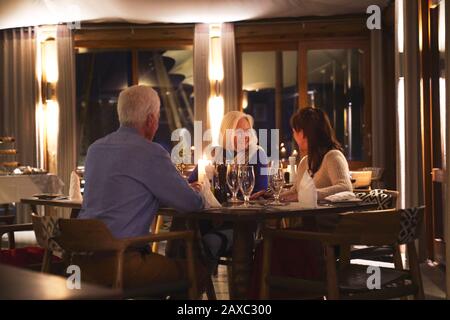 Amici anziani che si godono la cena nel ristorante Foto Stock