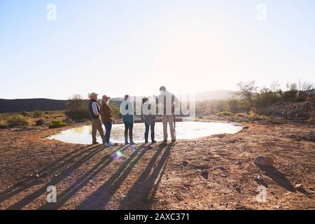 Safari guida turistica e gruppo in acqua nella soleggiata prateria del Sud Africa Foto Stock