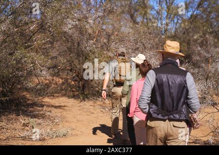 Safari guida turistica gruppo leader nella soleggiata prateria Sud Africa Foto Stock