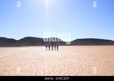 Safari gruppo tour a piedi lungo la soleggiata terra cracked Sud Africa Foto Stock