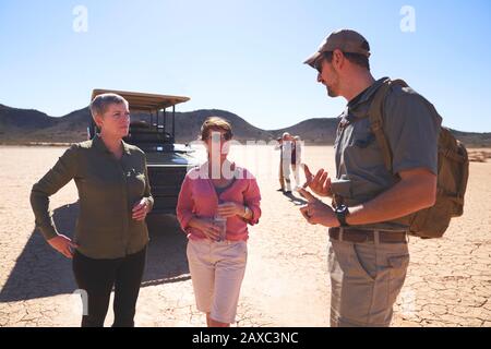 Guida turistica Safari che parla con le donne nel deserto soleggiato del Sud Africa Foto Stock