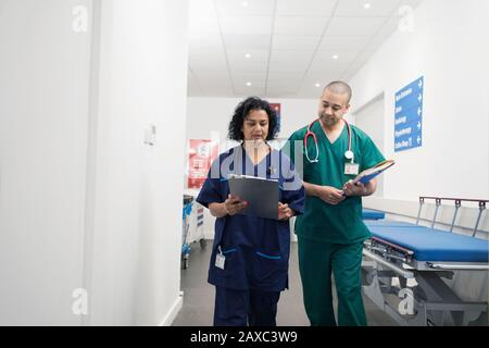 Medici con carta medica che fa giri nel corridoio dell'ospedale Foto Stock