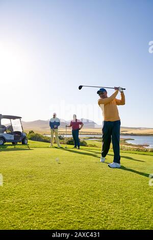 Maschio golfista che si decollano al sole campo da golf tee box Foto Stock