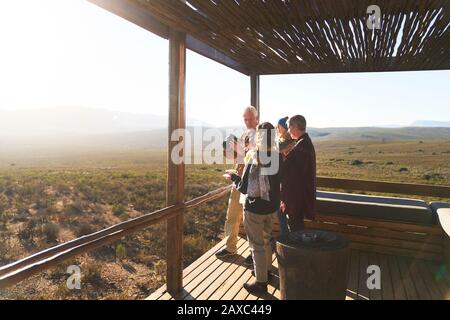 Amici anziani su soleggiato safari Lodge balcone Sud Africa Foto Stock