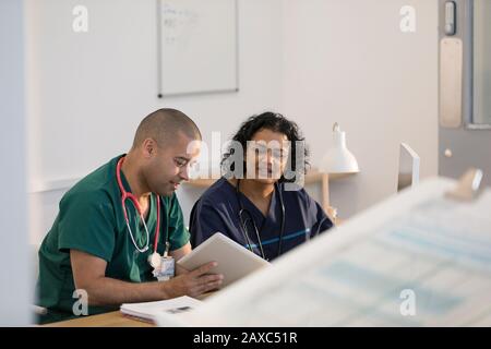 Medici che utilizzano tablet digitali in clinica Foto Stock