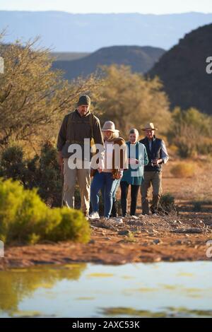 Guida turistica safari che guida il gruppo nella soleggiata riserva naturale Foto Stock