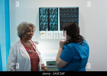 Medico e infermiere di sesso femminile che discutono i raggi X in ospedale Foto Stock