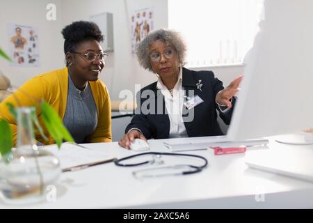 Incontro medico femminile con il paziente al computer presso l'ufficio dei medici Foto Stock