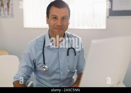 Ritratto medico sicuro maschio che lavora al computer in ufficio medici Foto Stock