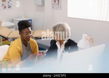 Medico femminile che prescrive il farmaco al paziente nell'ufficio del medico Foto Stock