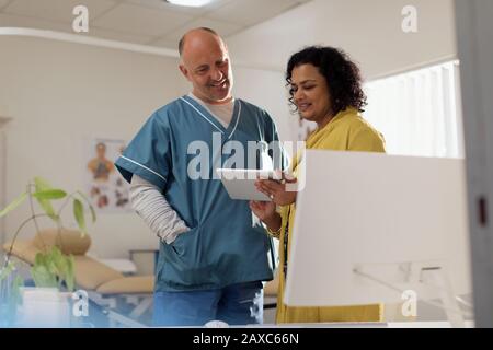 Medici consulenza, utilizzando tablet digitale in ufficio medici Foto Stock