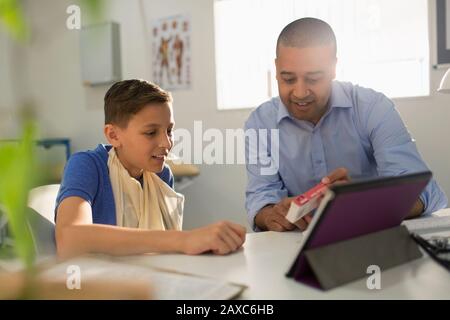 Pediatra maschile prescrizione di farmaci per il paziente ragazzo in ufficio medici Foto Stock