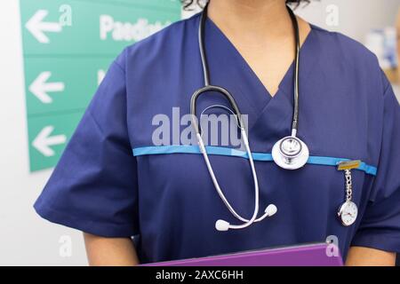 Primo piano medico femminile che indossa scrub e stetoscopio in ospedale Foto Stock