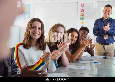 Gli studenti delle scuole superiori felici che battano nella classe di discussione Foto Stock