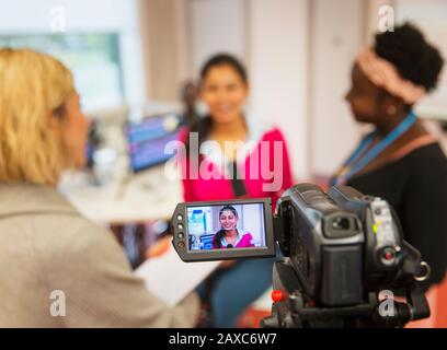 Video camera filmare femminile comunità studenti di giornalismo college in classe Foto Stock