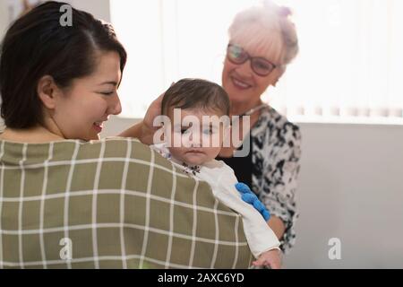 Ritratto ragazza cute del bambino che è esaminata dal pediatra nell'ufficio dei medici