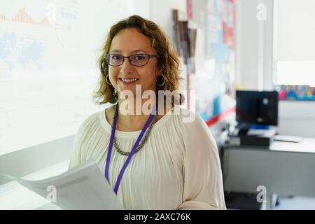 Insegnante di sesso femminile con ritratto a schermo di proiezione in classe Foto Stock