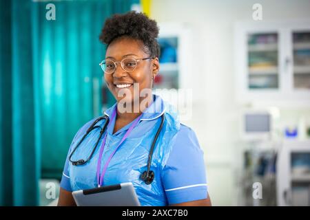 Infermiere femminile con ritratto sicuro con tablet digitale in ospedale Foto Stock