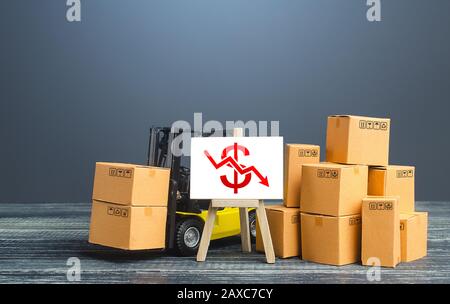 Carrello elevatore a forche vicino a scatole e cavalletto con freccia rossa del dollaro in basso. Calo dei tassi di commercio e di produzione, calo delle vendite. Cattiva commercializzazione, riduzione dei prezzi. Bassa imp Foto Stock