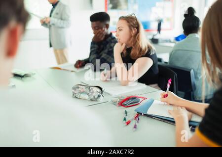 Studenti di scuola superiore che studiano a tavoli in classe Foto Stock