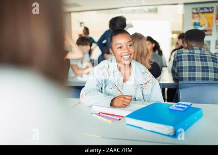 Felice, sicuro studente di High School ragazza che studia in classe Foto Stock