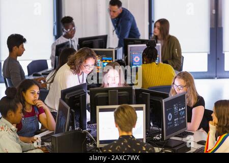 Giovani studenti e insegnanti che utilizzano computer in laboratorio Foto Stock