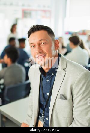 Ritratto fiducioso maschile insegnante di scuola superiore in classe Foto Stock