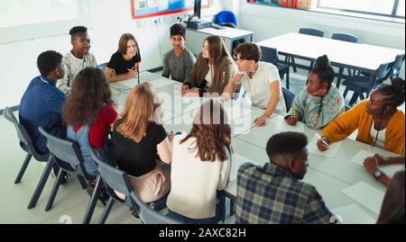 Gli studenti delle scuole superiori che parlano a tavola nella classe di discussione Foto Stock