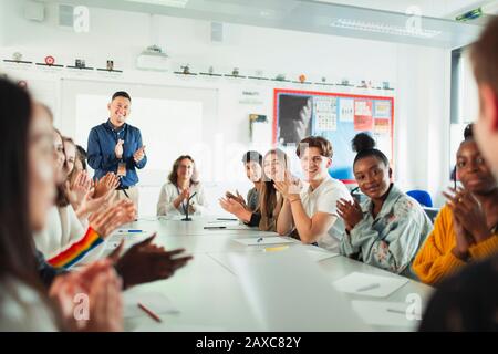 Studenti di scuola superiore e insegnante che batte classe di dibattito Foto Stock