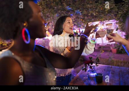 Buone giovani donne amici bere cocktail a festa in cortile Foto Stock