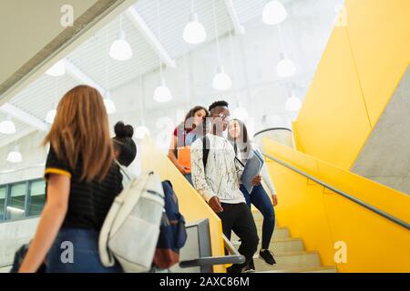 Junior studenti alti scendere le scale Foto Stock