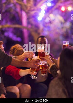 Amici che brindano bicchieri di birra a festa Foto Stock