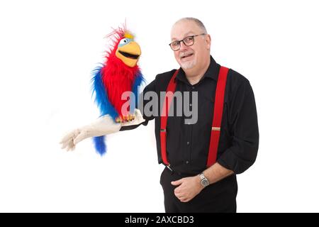 Un ventriloquista con un pappagallo sul suo braccio Foto Stock