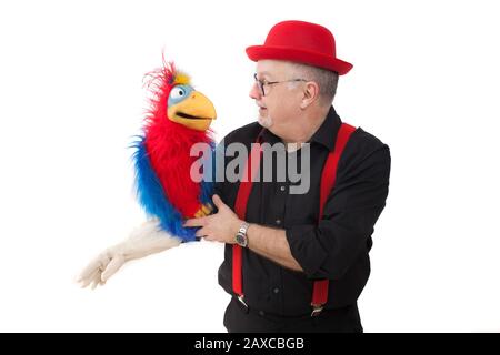 Un ventriloquista con un pappagallo sul suo braccio Foto Stock