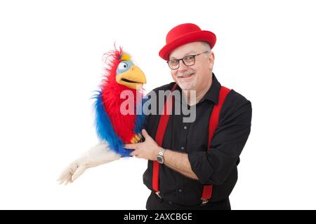 Un ventriloquista con un pappagallo sul suo braccio Foto Stock