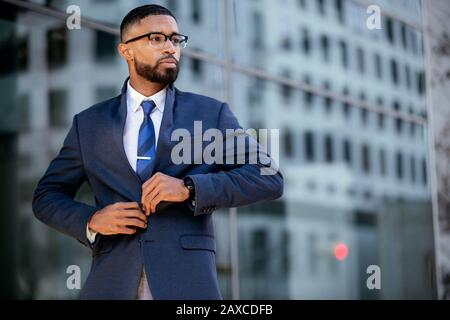 Intelligente e intelligente uomo d'affari afroamericano moderno di successo in abito elegante e occhiali, stile di vita candid ritratto Foto Stock