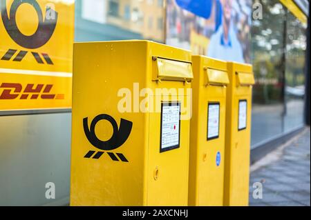 Berlino, Germania - 5 ottobre 2019: Diverse caselle postali con il logo del Post tedesco in giallo tipico su un marciapiede a Berlino, Germania. Foto Stock