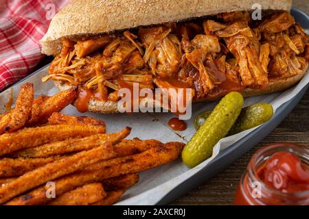 Cric-frutta vegan barbecue su pane di hoagie di grano intero. Fagioli cotti in stile meridionale, patatine fritte e insalata di cavolo. Foto Stock