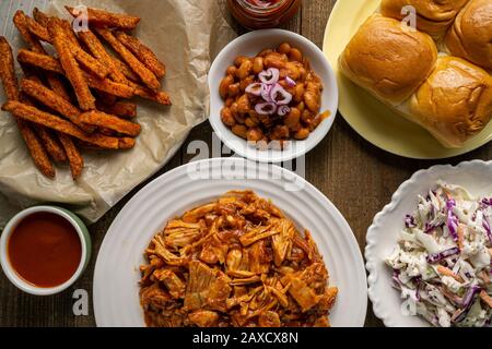 Piatto grigliato vegano. Jack-frutta alla griglia, fagioli al forno in stile meridionale, insalata di cavolo, panini per la cena e patatine fritte dolci. Foto Stock