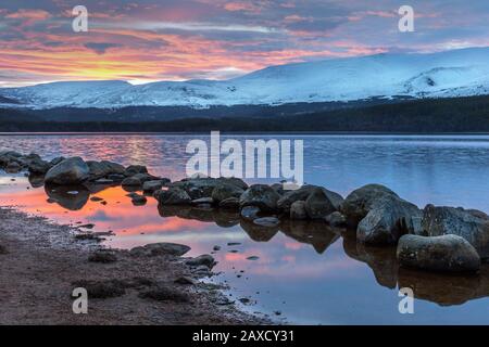 Bella luce di primo mattino su Loch Morlich, con montagne innevate in lontananza, Scozia, Regno Unito, Europa Foto Stock