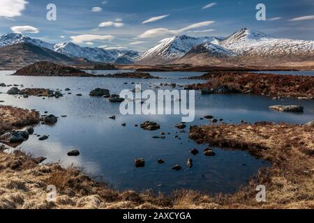 Montagne innevate intorno Lochan na h-Achlaise, Rannoch Moor Argyll e Bute Scottish Highlands UK Foto Stock