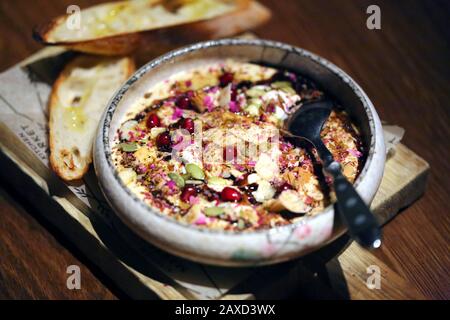 Deliziosa foto di hummus con semi di melograno in un caffè Foto Stock