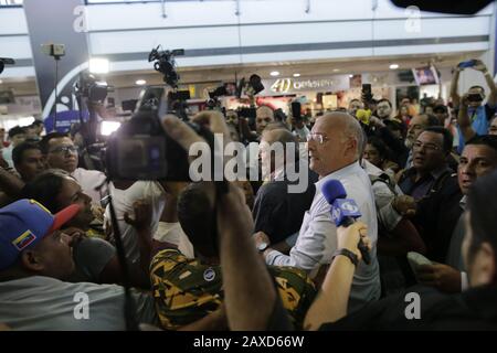 Caracas, Venezuela. 11th Feb, 2020. Williams Davila (M.), vice dell'opposizione venezuelana, è circondato da giornalisti e telecamere mentre attende l'arrivo del leader dell'opposizione Guaido all'aeroporto. Dopo un viaggio all'estero di circa tre settimane, il presidente provvisorio Guaido, autonominato, atterra a Caracas. Durante il suo viaggio all’estero, il presidente degli Stati Uniti Trump ha promesso al leader dell’opposizione un ulteriore sostegno. I sostenitori del governo venezuelano lo vedono come un 'traditore'. Credito: Rafael Hernandez/Dpa/Alamy Live News Foto Stock